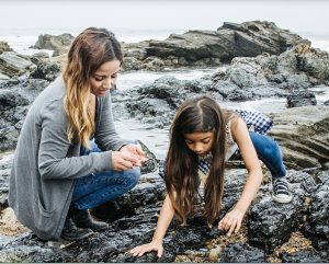 Woman and child exploring tide pools as part of ecological education program sponsored by Emerald Alliance