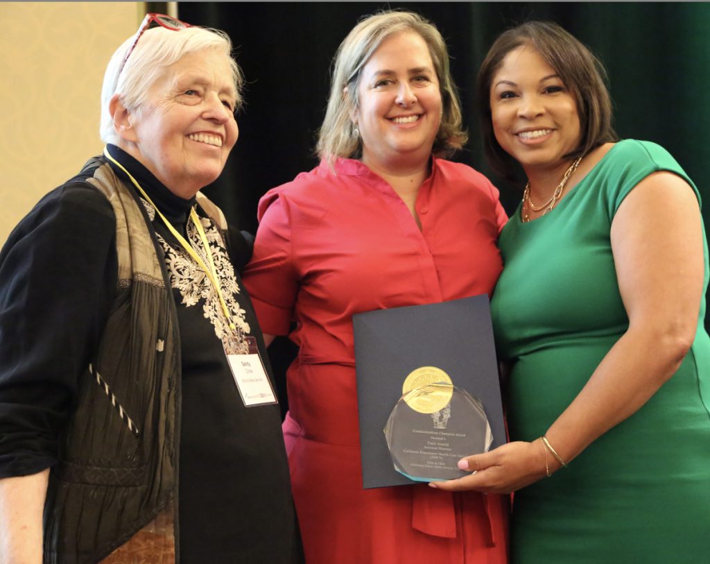 Sandy Close pictured with Regina Brown Wilson, right, executive director of California Black Media, present a Communications Champion Award to Tracy Arnold, Assistant Director at the Calif. Department of Health Care Services, at the EMS/CBM co-sponsored 2024 Ethnic Media Conference, Expo & Awards event. Photo: Peter Schurmann